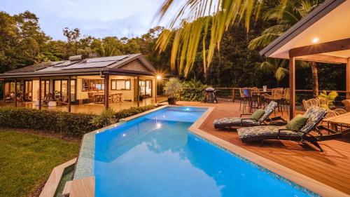 a backyard with a pool and a house at Port Douglas Alamanda Estate w Ocean Views & Pool in Craiglie