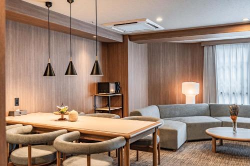 a living room with a couch and a table at Apartment Hotel 11 Dotonbori4 in Osaka