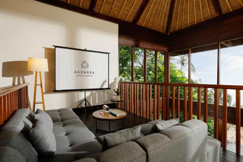 a living room with a large couch and a screen at Akohara Buahan Village Retreat in Payangan