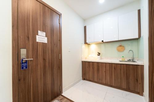a bathroom with a wooden door and a sink at Jade house Nguyễn Thị Minh Khai in Ho Chi Minh City