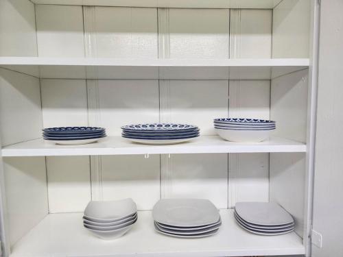 a shelf filled with blue and white plates and bowls at Relaxing Cozy Back House with Backyard in Upland