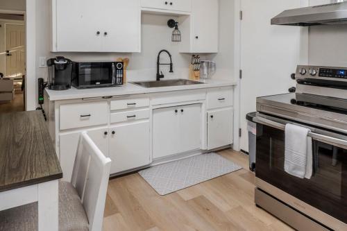 a kitchen with white cabinets and a sink and a stove at Relaxing Cozy Back House with Backyard in Upland
