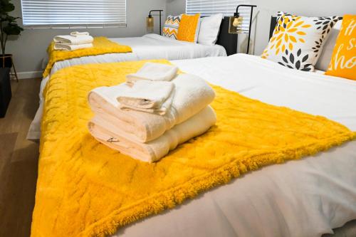 two beds with towels stacked on top of each other at Relaxing Cozy Back House with Backyard in Upland