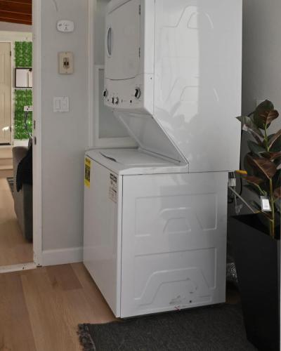 a white refrigerator freezer sitting in a room at Relaxing Cozy Back House with Backyard in Upland