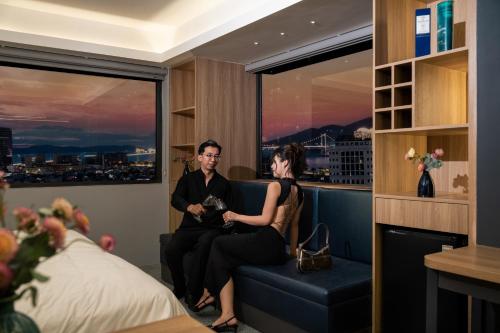 a man and a woman sitting in a chair in a hotel room at Rest Hotel & Apartment in Da Nang