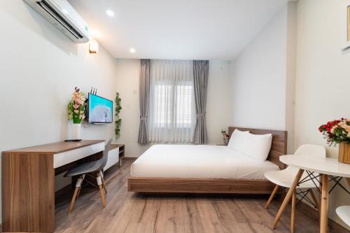 a hotel room with a bed and a desk at Jade house Nguyễn Thị Minh Khai in Ho Chi Minh City