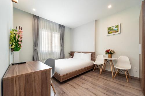 a hotel room with a bed and a table and chairs at Jade house Nguyễn Thị Minh Khai in Ho Chi Minh City