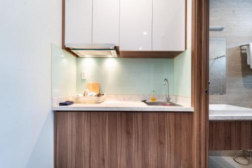 a kitchen with white cabinets and a sink at Jade house Nguyễn Thị Minh Khai in Ho Chi Minh City