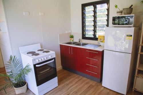 a kitchen with a white stove and a refrigerator at Mt Bundy Station in Adelaide River