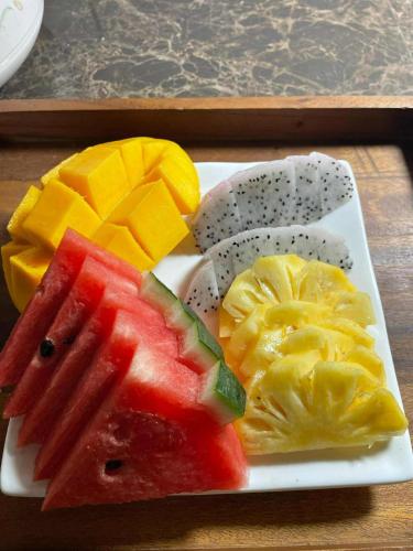 a plate of fruit on a wooden table at Friendlyhostel in Khao Sok