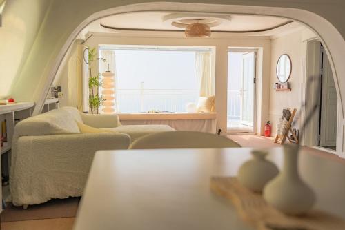 una sala de estar con un sofá y una mesa en Double-decker pension Ocean view duplex with a view of Cheongsapo Beach train #High-rise view#Ocean front view, en Busan