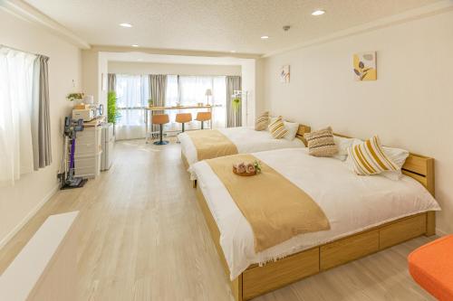 a bedroom with two beds and a living room at 2-minute walk from the station direct access to Ginza Ikebukuro next to Tokyo Dome in Tokyo