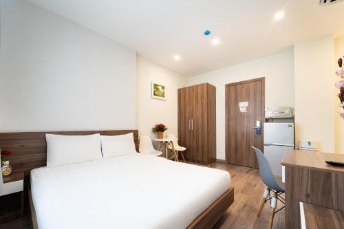 a bedroom with a bed and a desk and a kitchen at Jade house Nguyễn Thị Minh Khai in Ho Chi Minh City