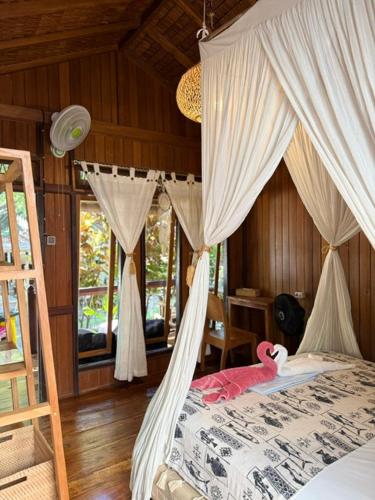 a bedroom with a bed with a canopy at 3WILL Bunaken Dive Resort in Bunaken