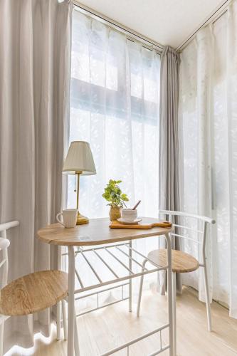 a table with a lamp and two chairs in front of a window at 2-minute walk from the station direct access to Ginza Ikebukuro next to Tokyo Dome in Tokyo