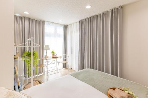 a bedroom with a bed and a desk and a window at 2-minute walk from the station direct access to Ginza Ikebukuro next to Tokyo Dome in Tokyo