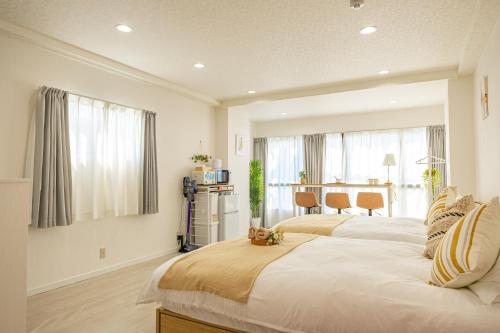 a bedroom with two beds and a dining room at 2-minute walk from the station direct access to Ginza Ikebukuro next to Tokyo Dome in Tokyo