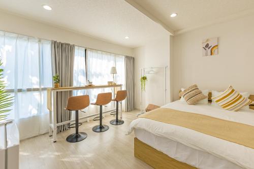 a bedroom with a bed and two chairs and a window at 2-minute walk from the station direct access to Ginza Ikebukuro next to Tokyo Dome in Tokyo