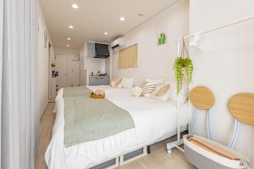 a bedroom with a large white bed and a tv at 2-minute walk from the station direct access to Ginza Ikebukuro next to Tokyo Dome in Tokyo