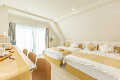 a hotel room with two beds and a desk at 2-minute walk from the station direct access to Ginza Ikebukuro next to Tokyo Dome in Tokyo
