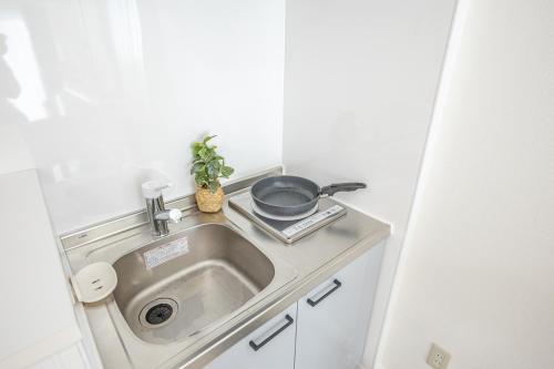 a kitchen sink with a frying pan on top of it at 2-minute walk from the station direct access to Ginza Ikebukuro next to Tokyo Dome in Tokyo