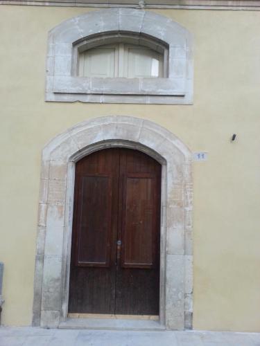 un edificio con porta in legno e finestra di Il Posto Ideale a Vittoria