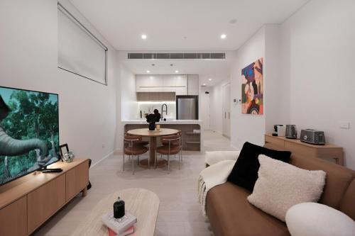 a living room with a couch and a table at 'CoCo' 2-BR Apt in the heart of Burwood with free parking in Sydney