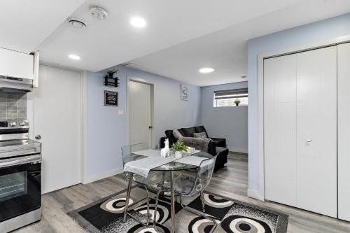 エドモントンにあるThe Cozy Cove - Modern Private Basement Suite with Comfort & Charm, Free Parking, WiFi, Netflix Close to airport & 18 minutes to West Edmonton Mallのキッチンとテーブルとソファのあるリビングルーム