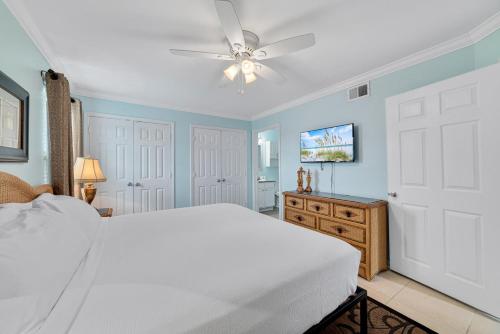 a bedroom with a white bed and a ceiling fan at Updated, Ground Floor Unit w/ Pool & Gym, Sleeps 6 in Gulf Shores
