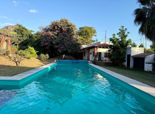 una piscina con agua azul frente a una casa en The Weiss House - Mountain, Pool and Rest, en Tepoztlán