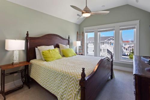 a bedroom with a bed with yellow pillows and a window at 1617 - Point Break in Corolla