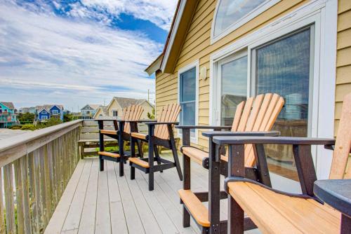 a row of chairs on a balcony with a view of the ocean at 6154 - Little Sushi in Nags Head