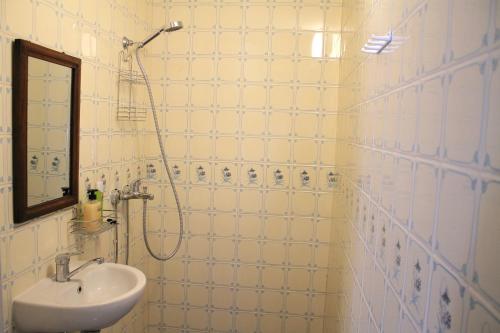 a white tiled bathroom with a sink and a shower at Trepimäe Guest Apartment in Viljandi