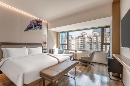 a hotel room with a bed and a large window at Shanghai Elong Hotel by the bund and Nanjing road Pedestrian street in Shanghai