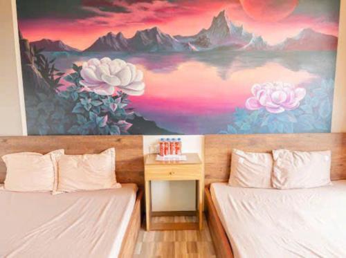 two beds in a room with a painting on the wall at Phúc Hưng Homestay- Venuestay in Ba Vì