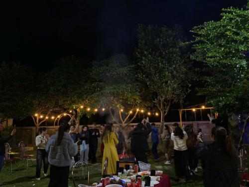 a group of people standing around a party at night at Phúc Hưng Homestay- Venuestay in Ba Vì