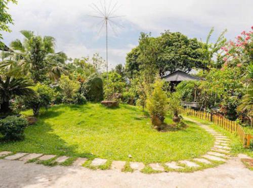 a garden with a circular path in the grass at Phúc Hưng Homestay- Venuestay in Ba Vì