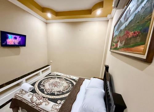 a bedroom with a bed and a painting on the wall at Hotel Alfa y Omega in San Benito