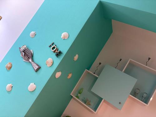 a room with blue walls and shells on the wall at Diego Rooms Vlora in Vlorë