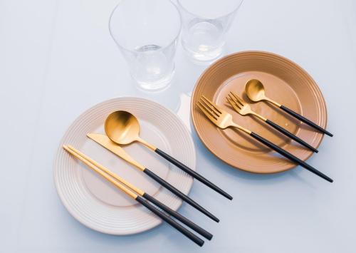 two plates with gold forks and spoons and glasses at kugenuma-surf-n-stay in Fujisawa