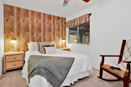 een slaapkamer met een bed, een stoel en een raam bij Casa bosque #2176 in Big Bear Lake