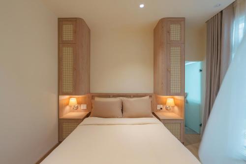 a bedroom with a bed and two windows at The Gardener by WeDalat in Da Lat