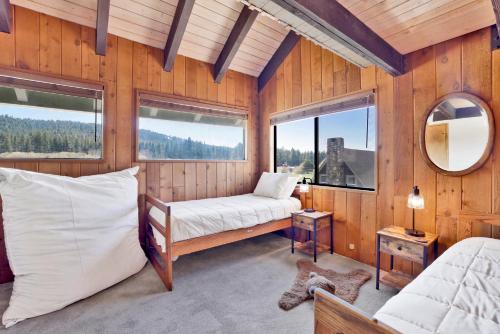 ein Schlafzimmer mit Bett und Fenstern in einer Hütte in der Unterkunft Golf & Ski Retreat #1443 in Big Bear Lake