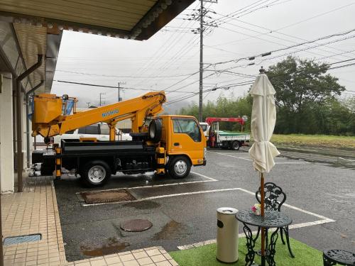 a yellow crane truck parked in a parking lot with an umbrella at Hotel Nissin Kaikan - Vacation STAY 02353v in Shiso