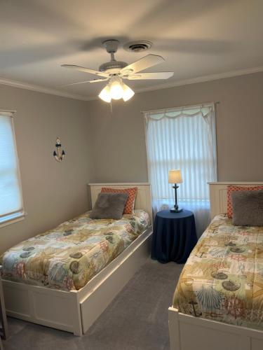 a bedroom with two beds and a ceiling fan at Flip Flop Drop - Rehoboth Beach - Community Pool! in Rehoboth Beach