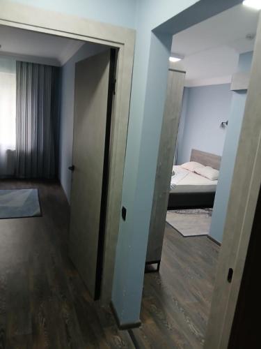 a room with a door leading to a room with a bed at Hotel Tahar in Almaty