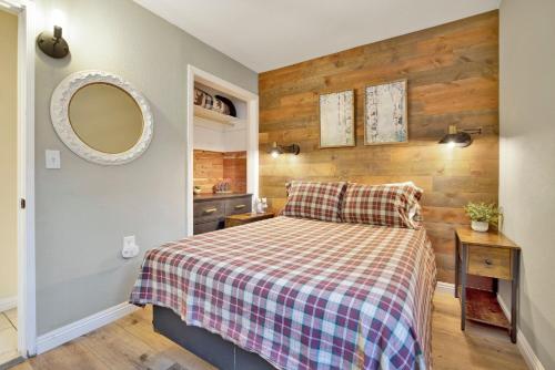 Schlafzimmer mit einem Bett mit einer karierten Decke und einem Spiegel in der Unterkunft Beary cozy cabin #2315 in Big Bear Lake