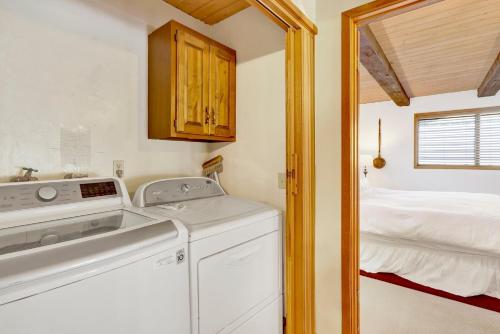 eine Waschmaschine und einen Trockner in einem Zimmer mit einem Bett in der Unterkunft Golf & Ski Retreat #1443 in Big Bear Lake