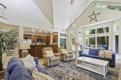ein Wohnzimmer mit blauen Sofas und eine Küche in der Unterkunft 57 Lawton Rd, Sea Pines Pet Friendly home in Hilton Head Island