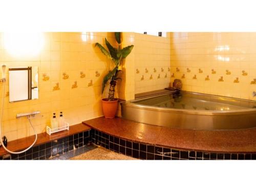a bathroom with a tub and a potted plant at Hotel Nissin Kaikan - Vacation STAY 02349v in Shiso